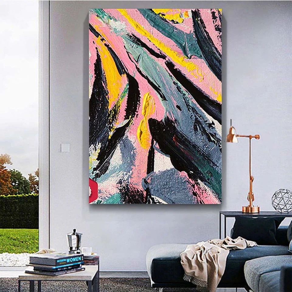 Abstract painting with pink, yellow, and black colors on a wall in a living room.