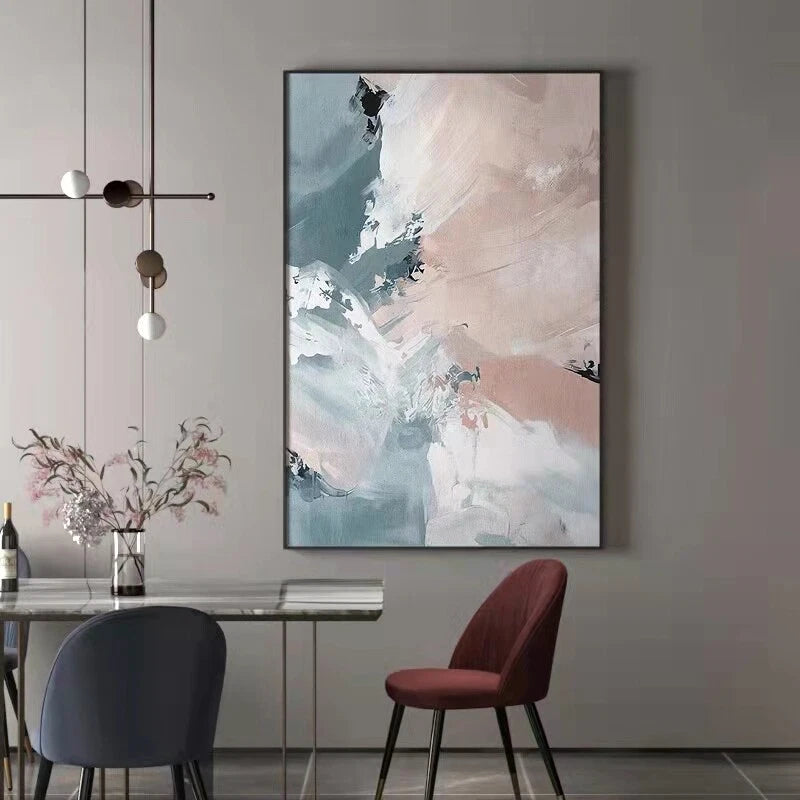Abstract painting on a wall above a dining table with chairs.