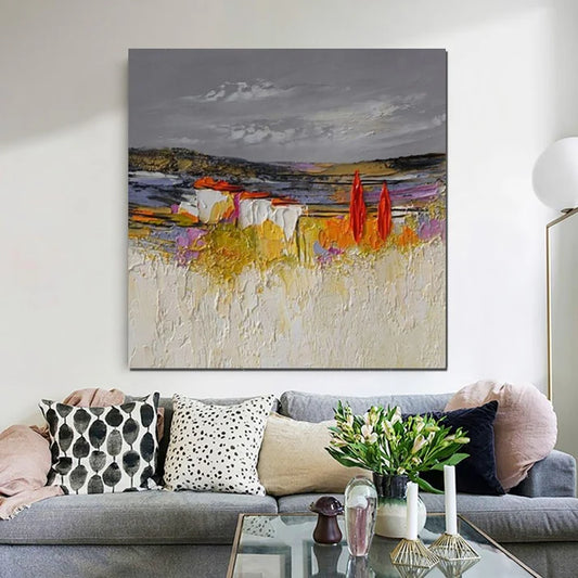 Living room with a gray sofa, decorative pillows, a coffee table with a vase of flowers, and a colorful abstract painting on the wall.