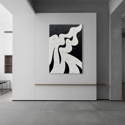 Abstract black and white artwork on a wall in a modern interior setting