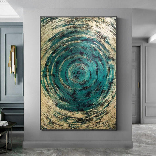 Abstract circular artwork with blue and beige tones on a gray wall.