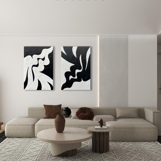 Modern living room with abstract black and white wall art, beige sofa, and coffee table.
