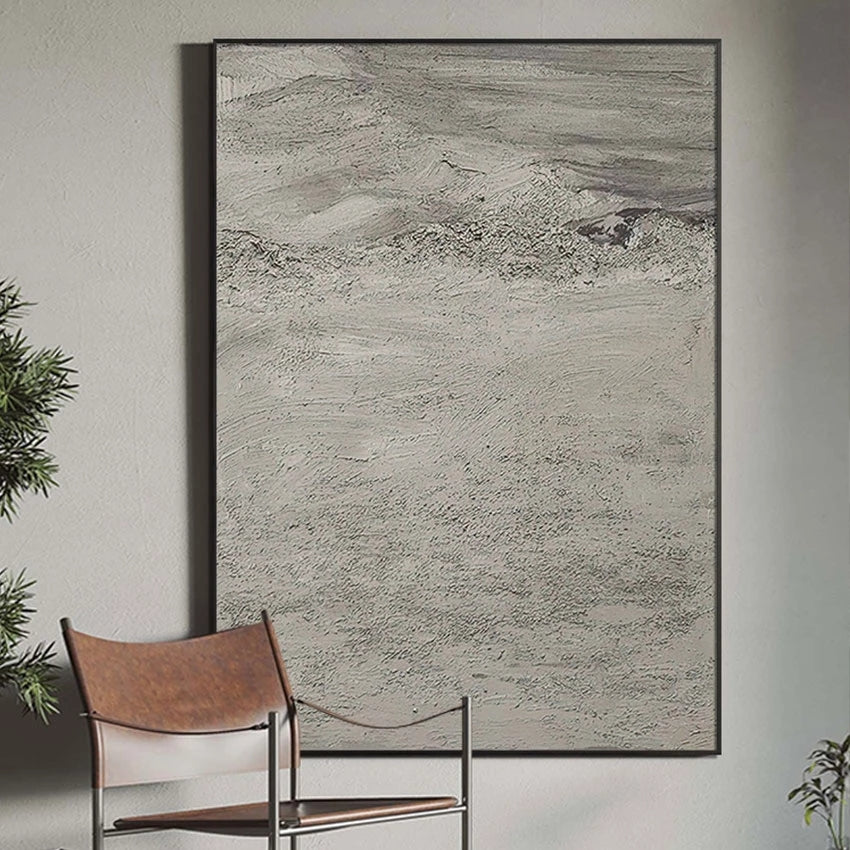 Abstract art piece on a wall with a chair and plants in the foreground