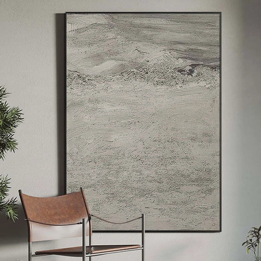 Abstract art piece on a wall with a chair and plants in the foreground