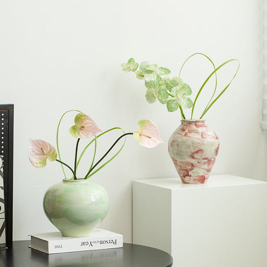 Two vases with flowers on a white surface