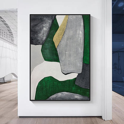 Abstract art piece with green, gray, and gold colors on a white wall.