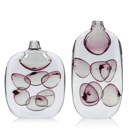 Two glass vases with purple and white abstract designs on a white background