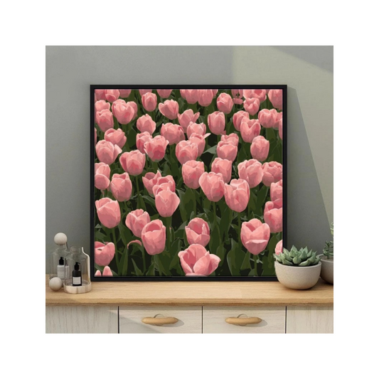 Framed artwork of pink tulips on a wall above a wooden shelf.