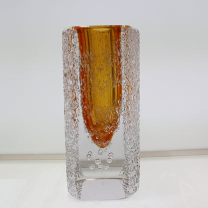 Glass vase with amber-colored top and textured base on a white background