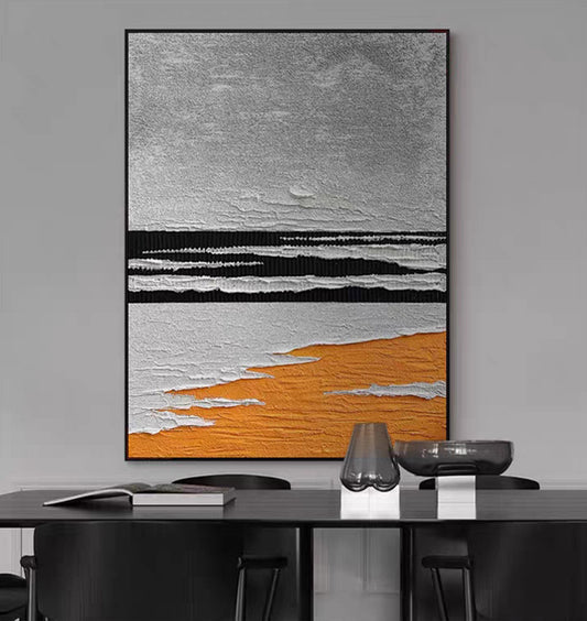 Abstract art piece with gray, black, and orange colors on a gray wall above a desk.