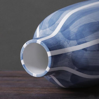 Blue and white ceramic vase on a dark surface with a gray background