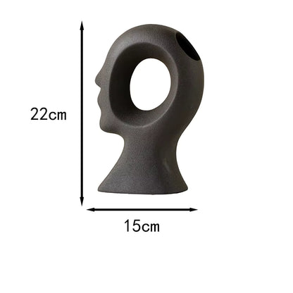 Gray sculpture of a face with dimensions labeled on a white background