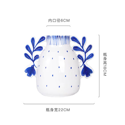 White vase with blue floral designs and measurements on a white background
