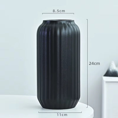 Black ribbed vase with dimensions on a light gray background