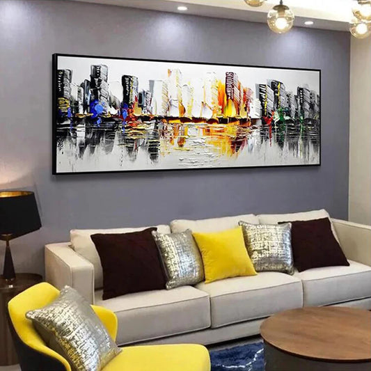 Living room with a large abstract cityscape painting on the wall, a gray sofa with colorful pillows, and a yellow chair.