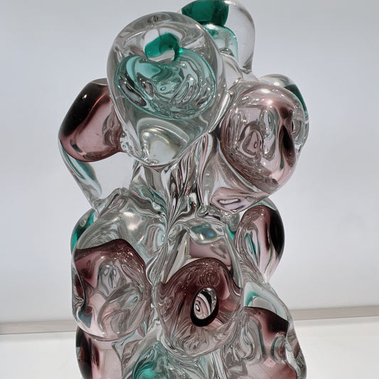 Glass sculpture with swirling patterns on a white background