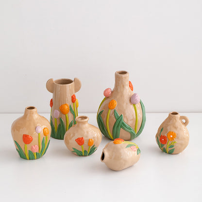 Set of small ceramic vases with floral designs on a white background