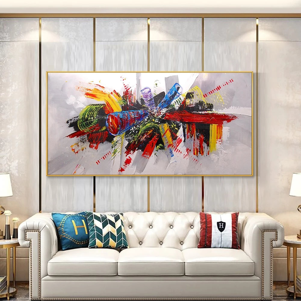 Colorful abstract painting above a white sofa in a living room setting.