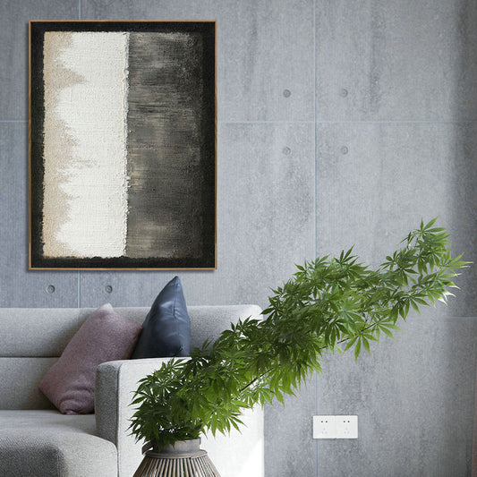 Abstract painting on a gray wall above a sofa with decorative pillows and a plant.