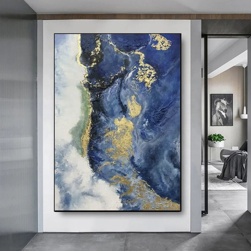 Abstract art piece with blue, gold, and white colors in a modern interior setting.