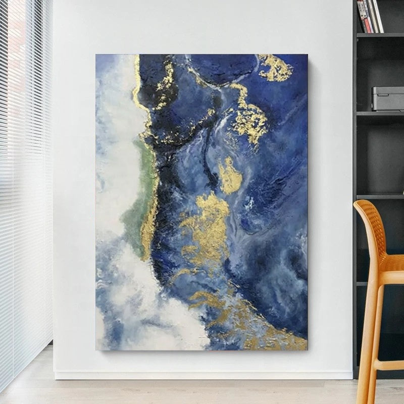 Abstract art piece with blue, gold, and white colors on a wall.