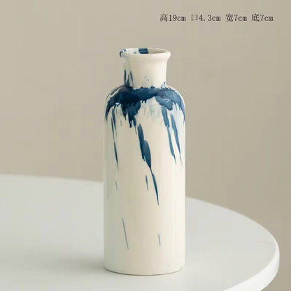 Cylindrical vase with blue abstract patterns on a beige background