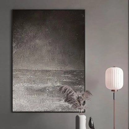 Abstract art piece on a wall with a lamp and decorative items below.