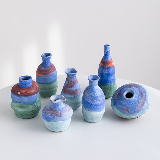 Set of ceramic vases with multicolored glaze on a white surface