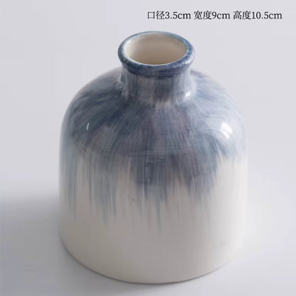 Cylindrical ceramic vase with blue gradient design on a white background
