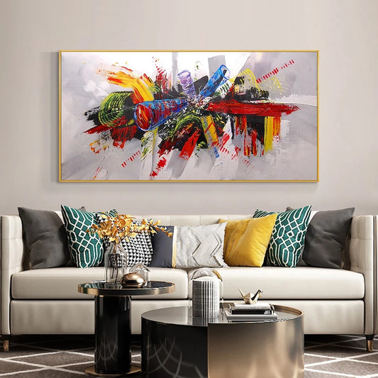 Abstract painting on a wall above a sofa with decorative pillows in a living room setting.