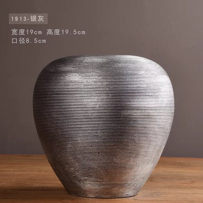 Textured vase on a wooden surface with a dark background