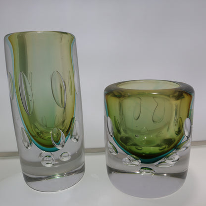 Two green glass tumblers on a white background