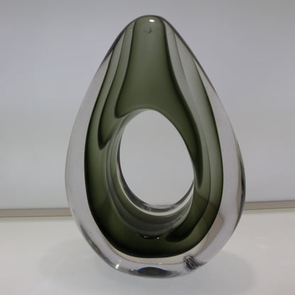 Teardrop-shaped object with reflective surface on a white background