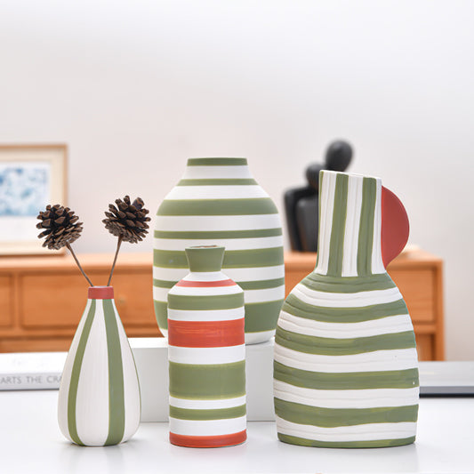 Set of striped ceramic vases on a table with a blurred indoor background