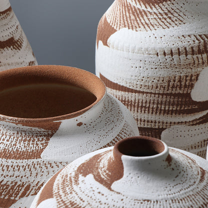 Close-up of ceramic pots with textured brown and white design on a gray background