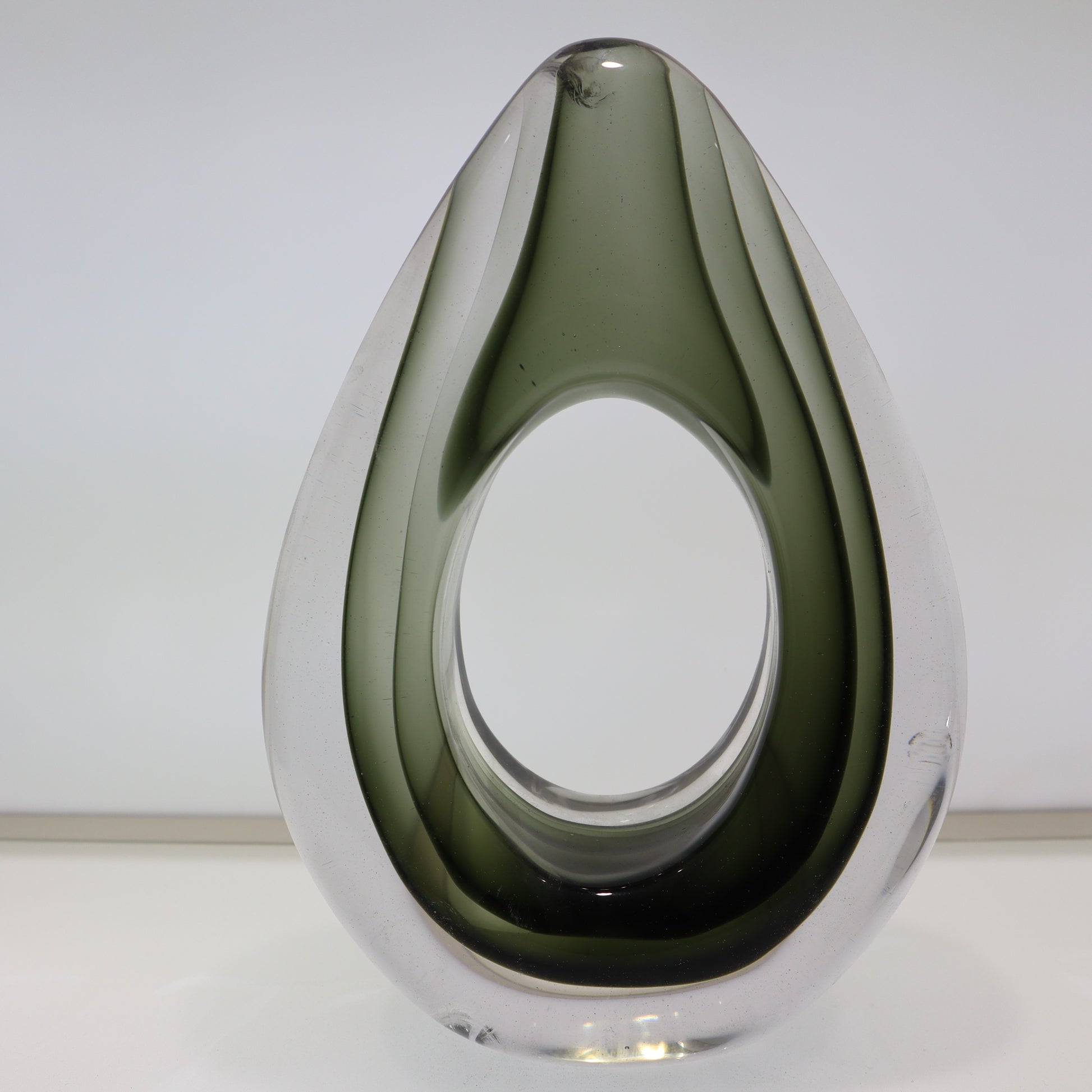 Modern glass vase with a teardrop shape on a white background