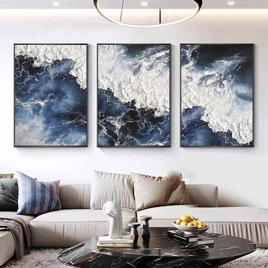 Three abstract wall art pieces in a living room setting.
