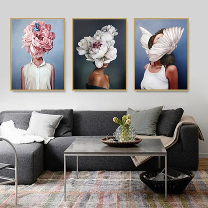 Living room with a gray sectional sofa, coffee table, and wall art featuring people with floral heads.