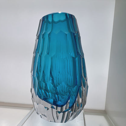 Blue glass vase with textured design on a white background