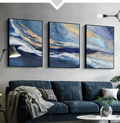 Three abstract paintings above a sofa in a living room setting.