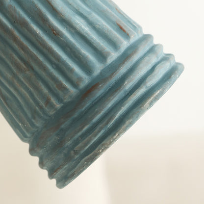 Textured blue ceramic object on a light beige background