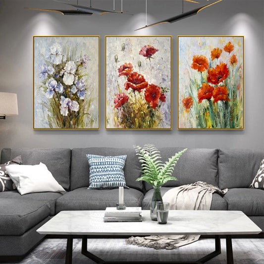 Living room with gray sectional sofa and three floral paintings on the wall.