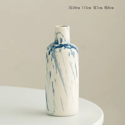 Marble-patterned ceramic vase on a white pedestal with a beige background