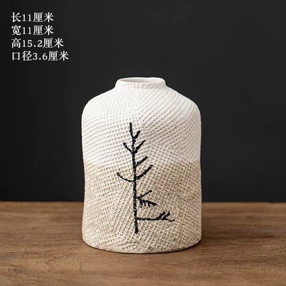 Textured vase with embroidered design on a wooden surface and dark background