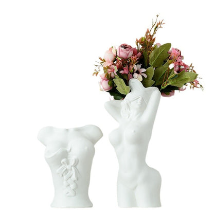White hand-shaped vase holding a bouquet of flowers on a white background
