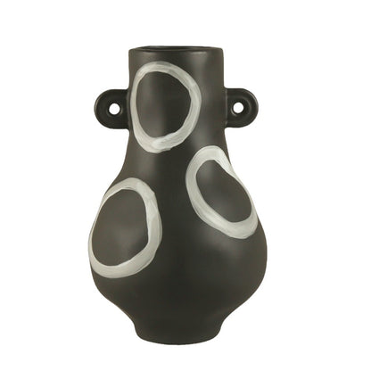 Black vase with white circular designs on a white background