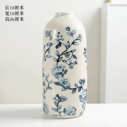 Cylindrical ceramic vase with blue floral patterns on a white background