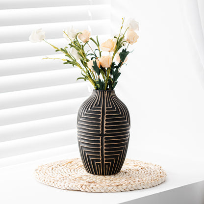 Decorative vase with geometric pattern on a white surface with flowers.