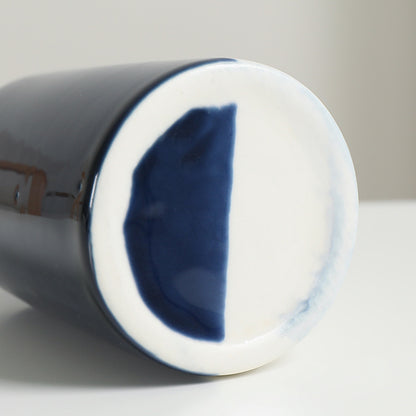 Close-up of a ceramic mug with blue interior on a white background