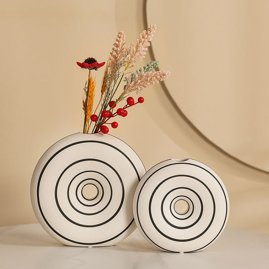 Two decorative vases with circular patterns on a beige background